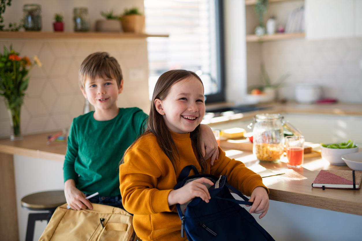 Des enfants le matin dans la cuisine préparant la rentrée scolaire