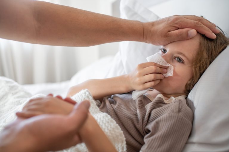 enfant dans son lit avec un mouchoir