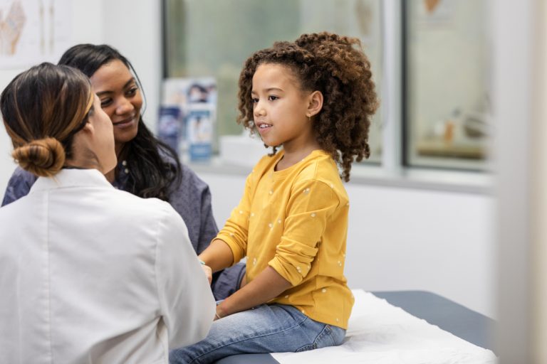 jeune fille avec un haut jaune parlant avec un médecin